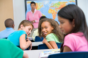 Girls laughing at another student in class