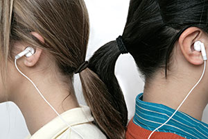 Teens sharing earbuds