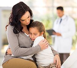 Mother hugging child in doctor's office