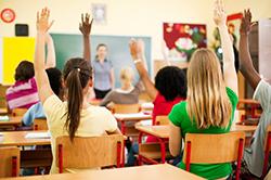 Teens raising their hand in class